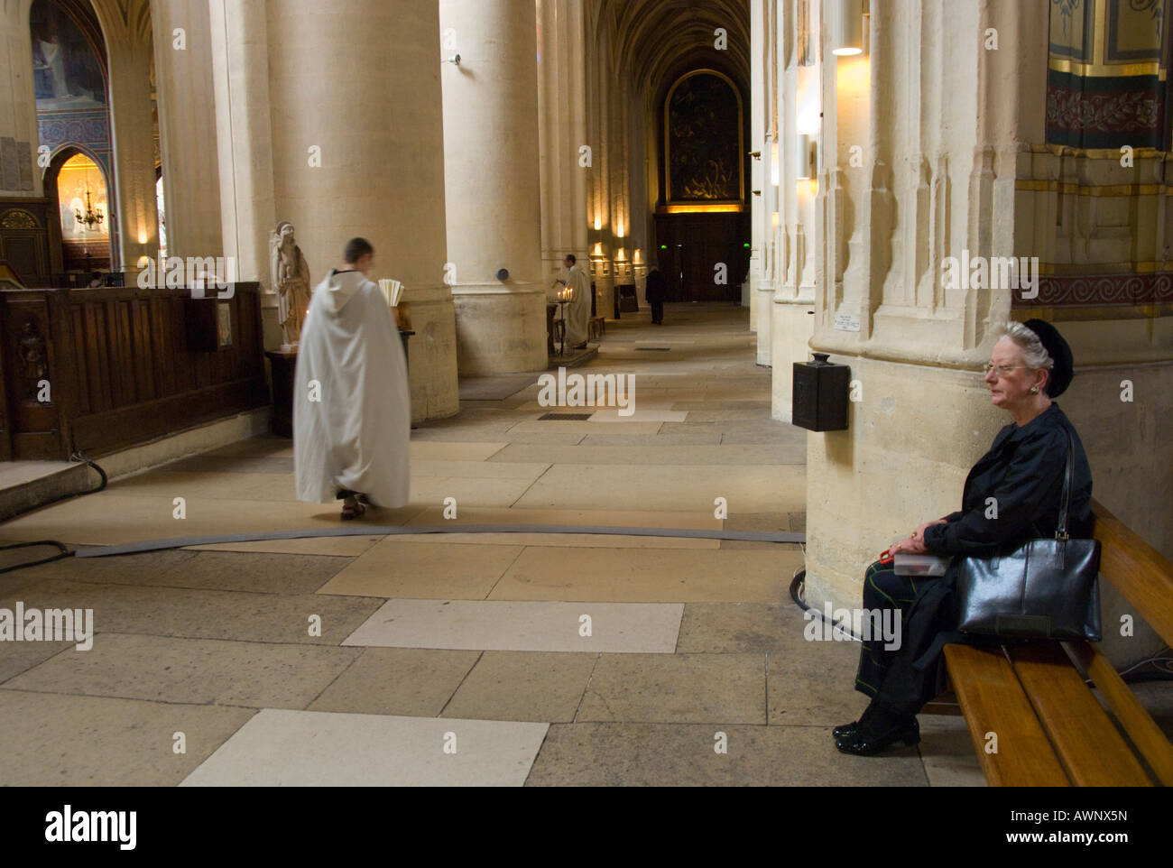 Frankreich Paris 4 Eglise Saint Gervais Innenraum ältere Frau sitzen auf Bank und Priester vorbei Stockfoto