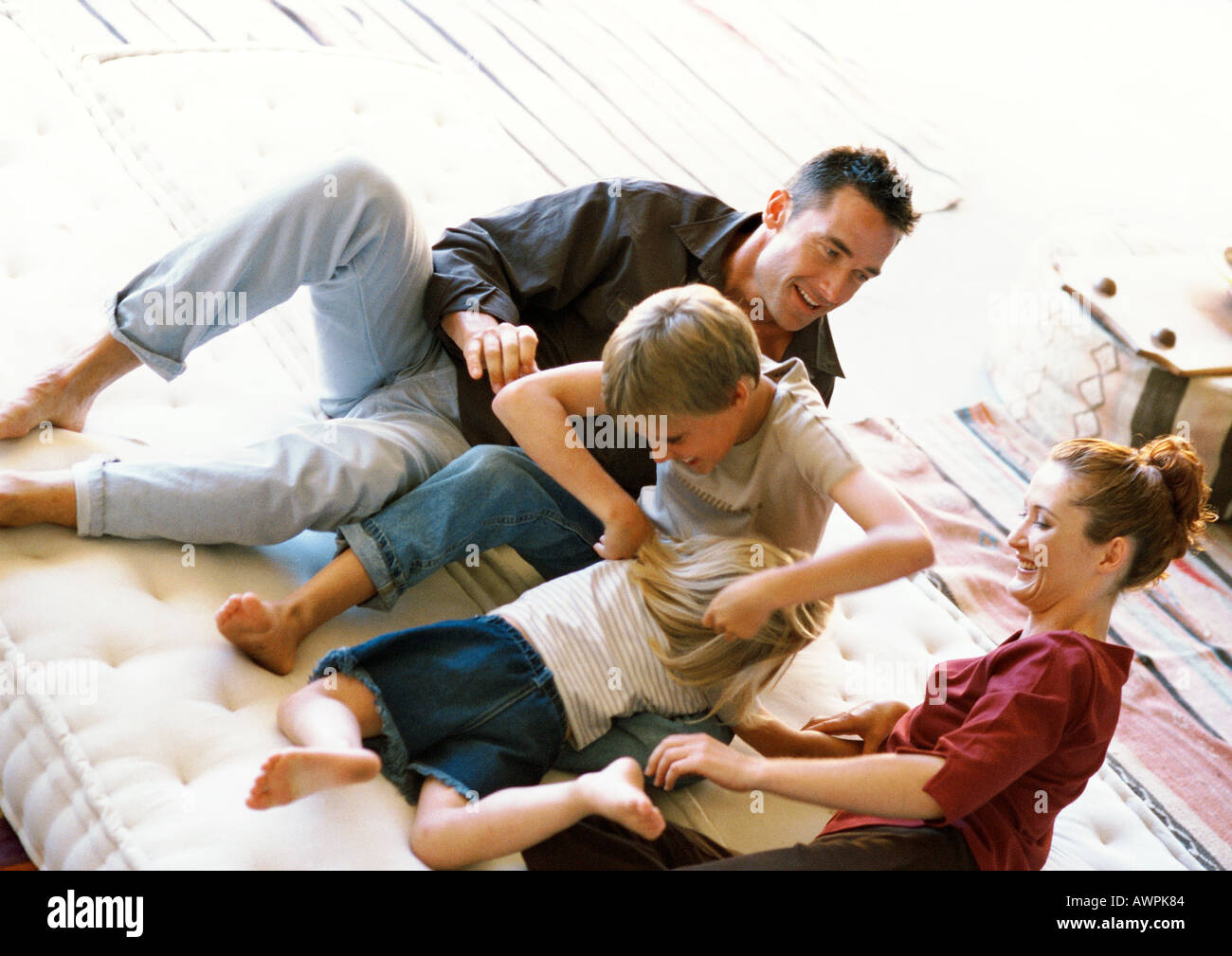 Eltern und Kinder spielen auf Matratze Stockfoto