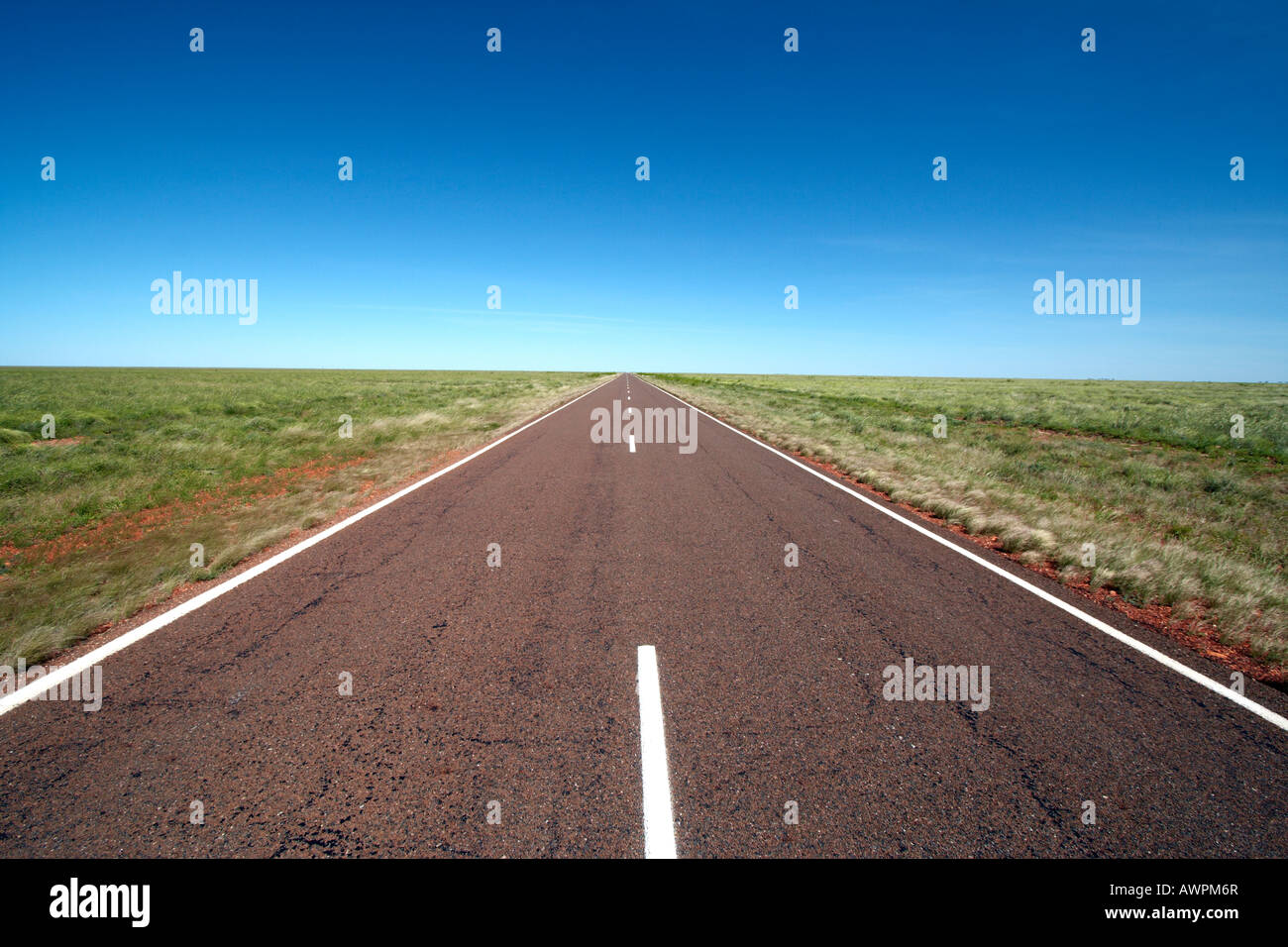 Gerade Desert Road unter einem strahlend blauen Himmel in Northern Territory Australien Stockfoto