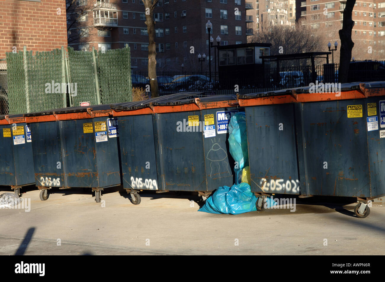 Müllcontainer gefüllt mit recycling Material sitzen hinter einem Mehrfamilienhaus in New York City Stockfoto