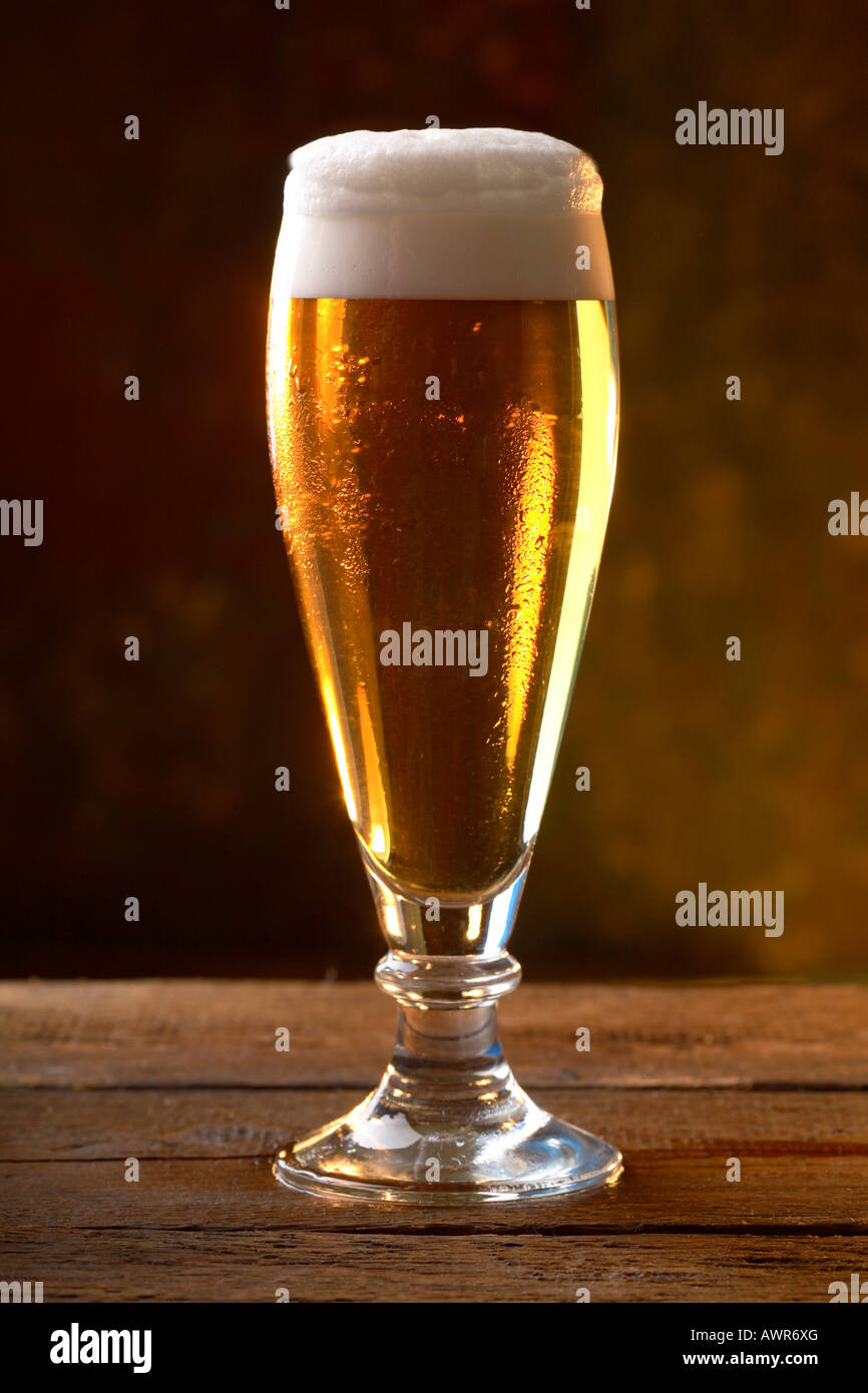 Glas Bier serviert auf einem Holztisch Stockfoto