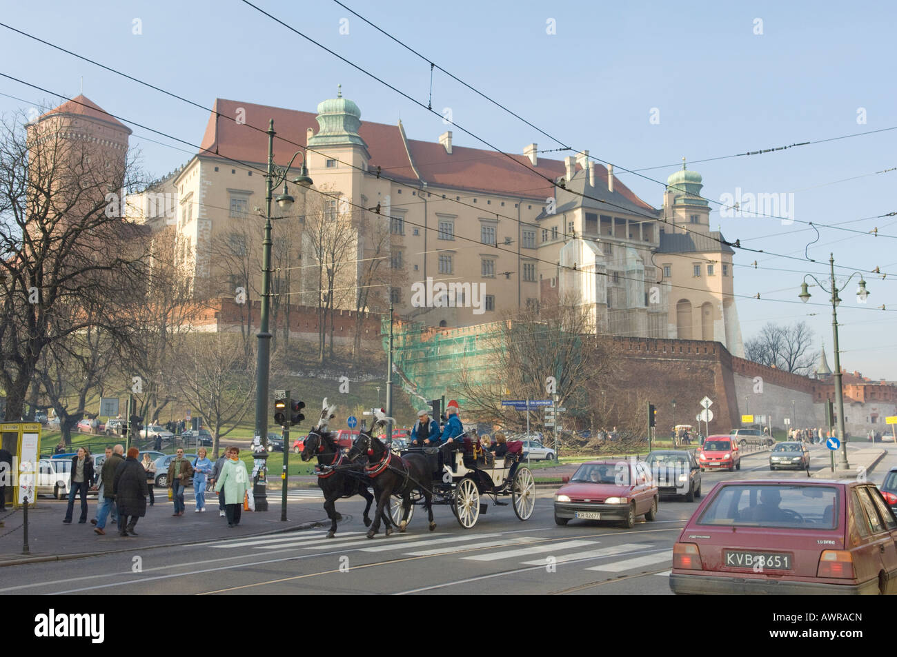 Pferdekutsche auf der Straße mit Schloss Wawel und der Hügel im Hintergrund in Krakau, Polen Stockfoto