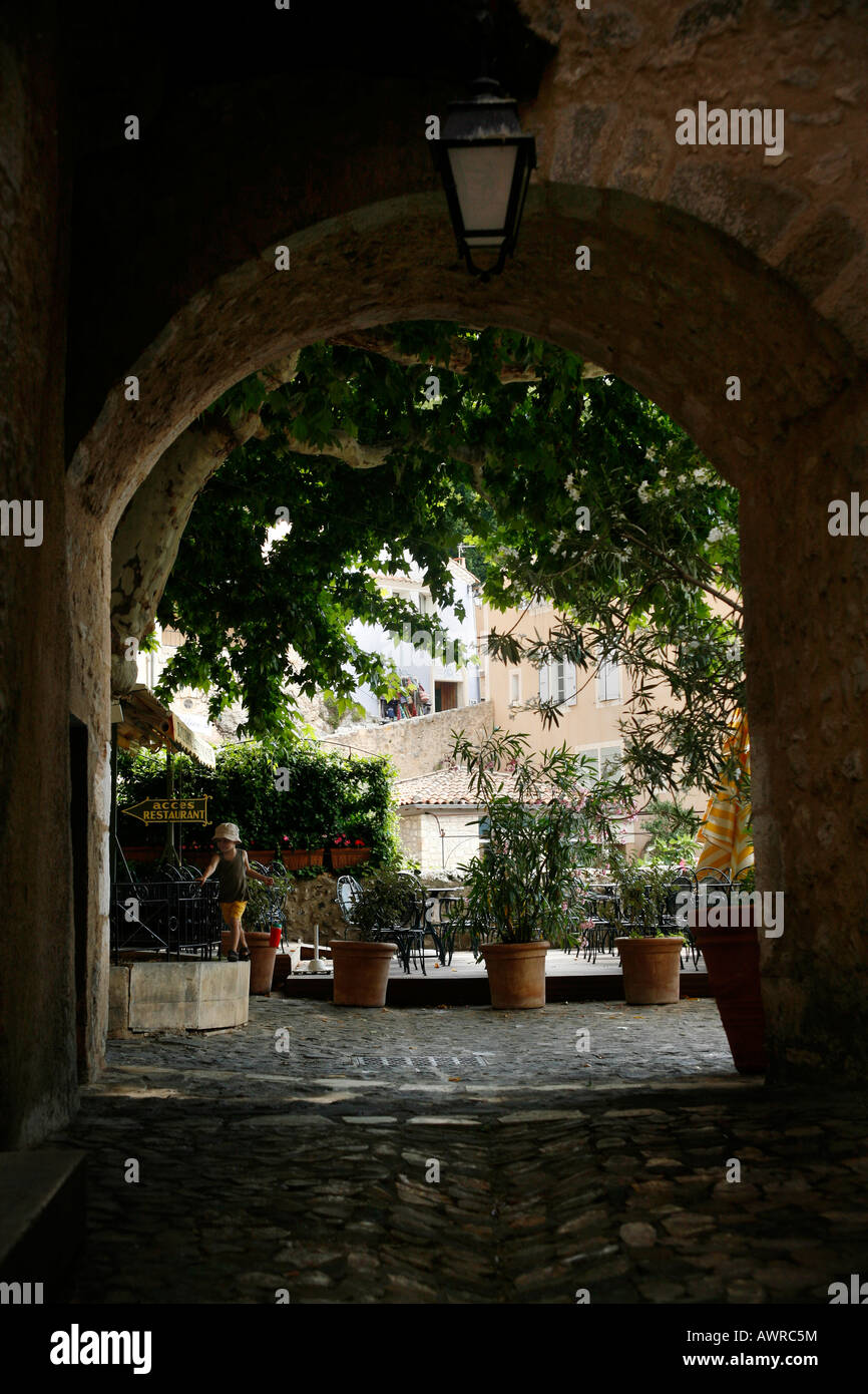 Ein Kind spielt in einem Torbogen, Moustiers-Sainte-Marie, Alpes-de-Haute-Provence, Frankreich Stockfoto