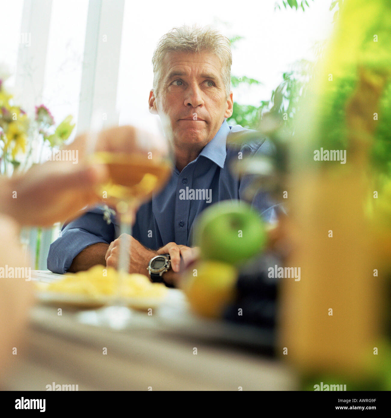 Reifer Mann am Tisch sitzen Stockfoto