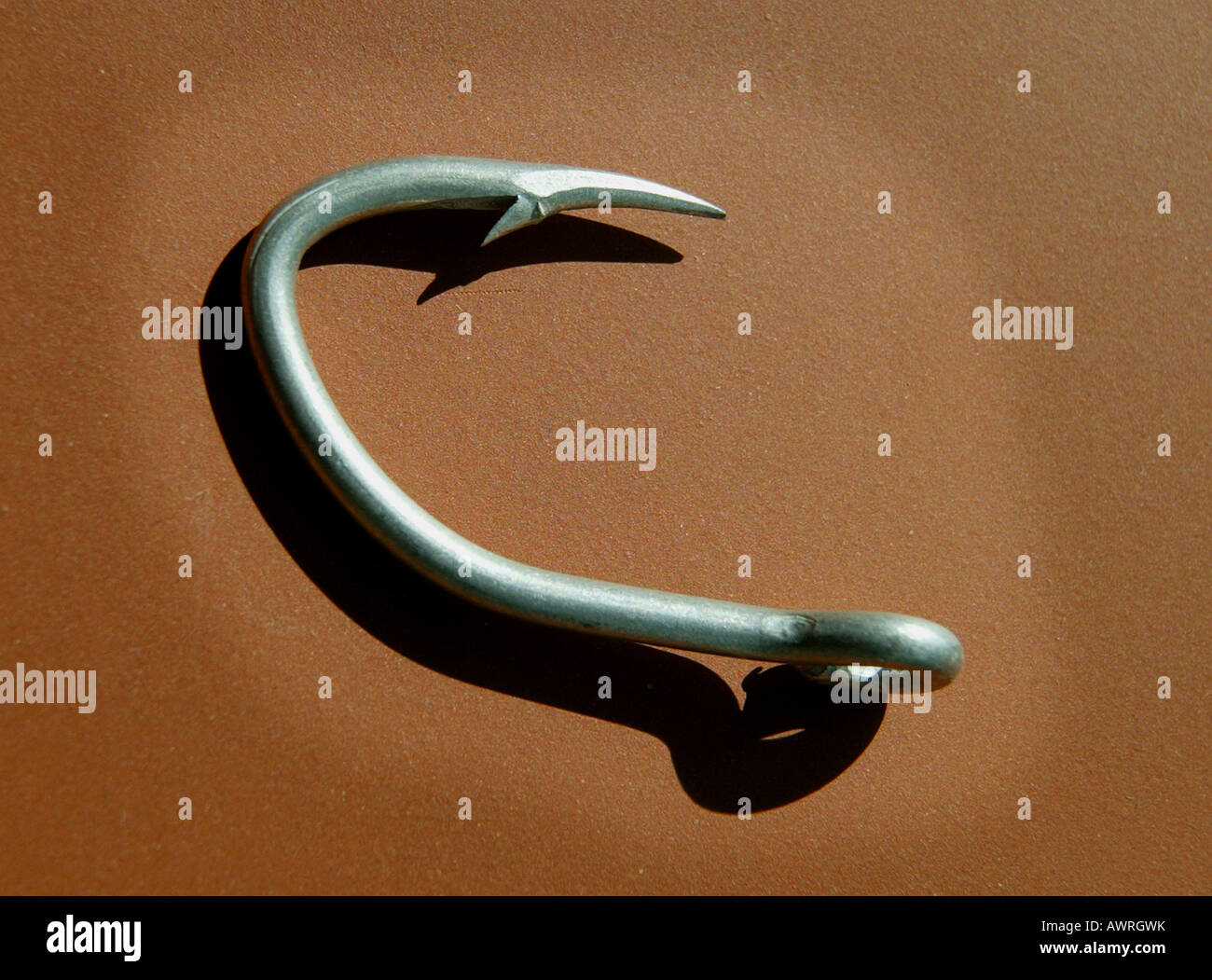 Silber Angelhaken mit Widerhaken Punkt auf orangem Hintergrund Stockfoto