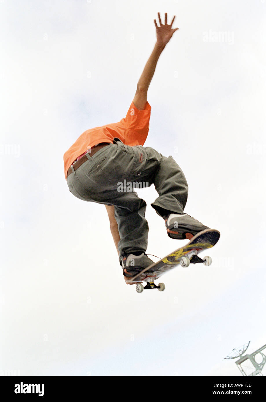 Junger Mann auf Skateboard, springen, Luft, niedrigen Winkel, Rückansicht. Stockfoto