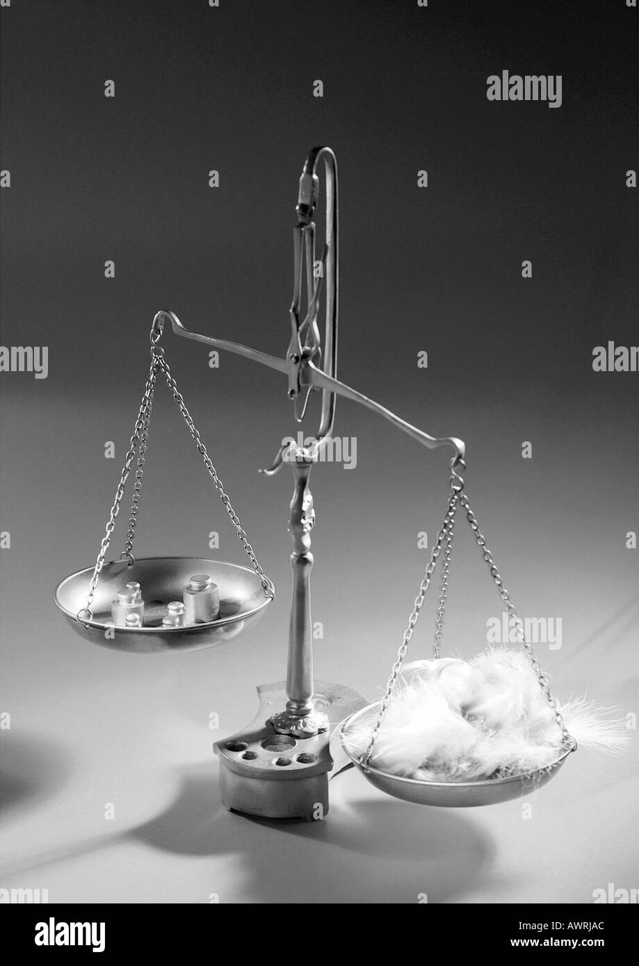 Waage halten Federn auf der einen Seite und Gewichte auf der anderen Stockfoto