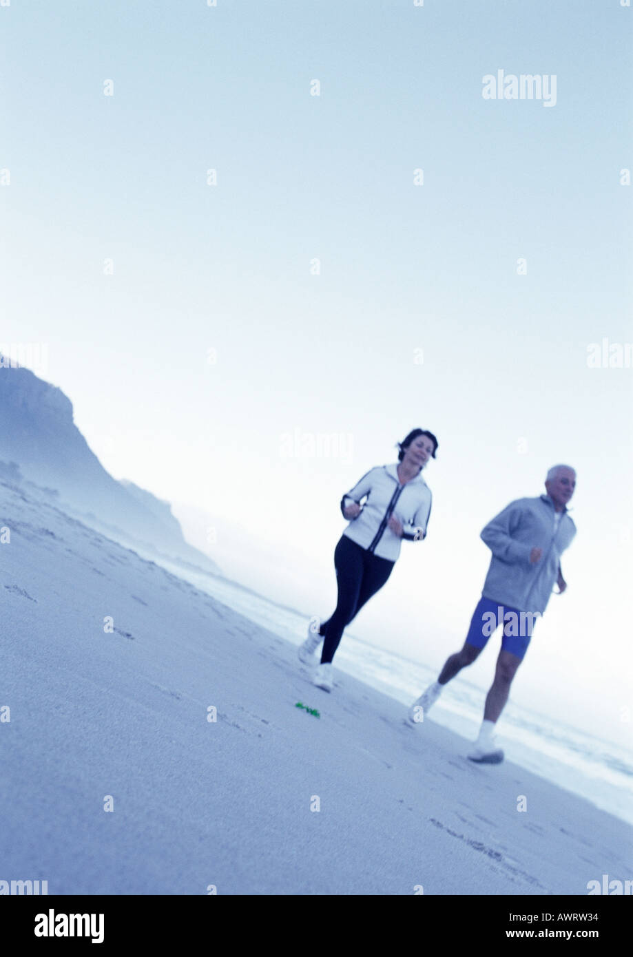 Reifer Mann und Frau läuft am Strand Stockfoto