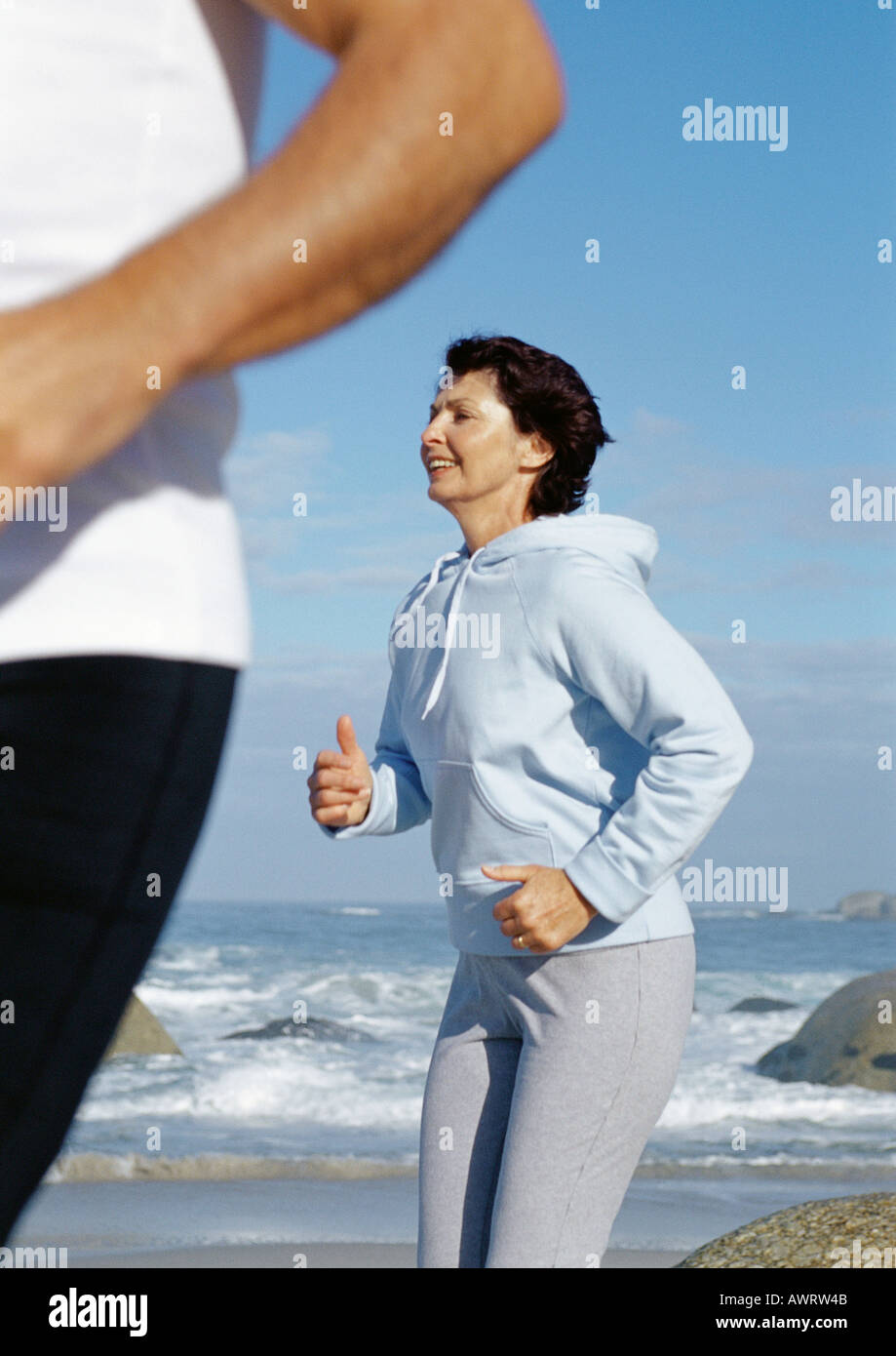 Älteres Paar am Strand laufen Stockfoto