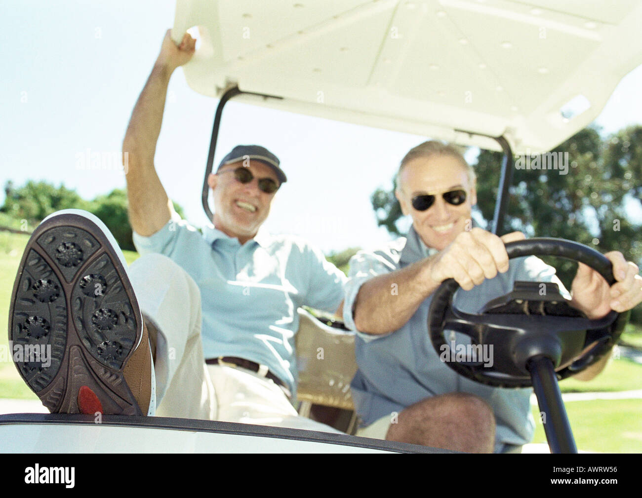 Zwei reife Männer im Golf-Cart, lächelnd, Nahaufnahme Stockfoto