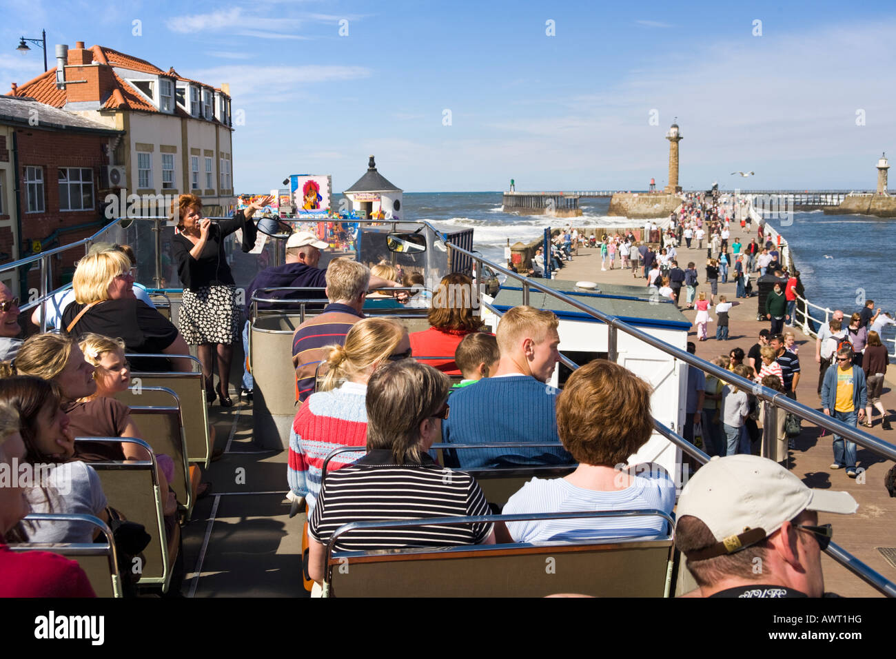 Touristenführer erklärt Besuchern die Sehenswürdigkeiten in einem offenen Bus neben dem Hafen in Whitby, North Yorkshire UK Stockfoto