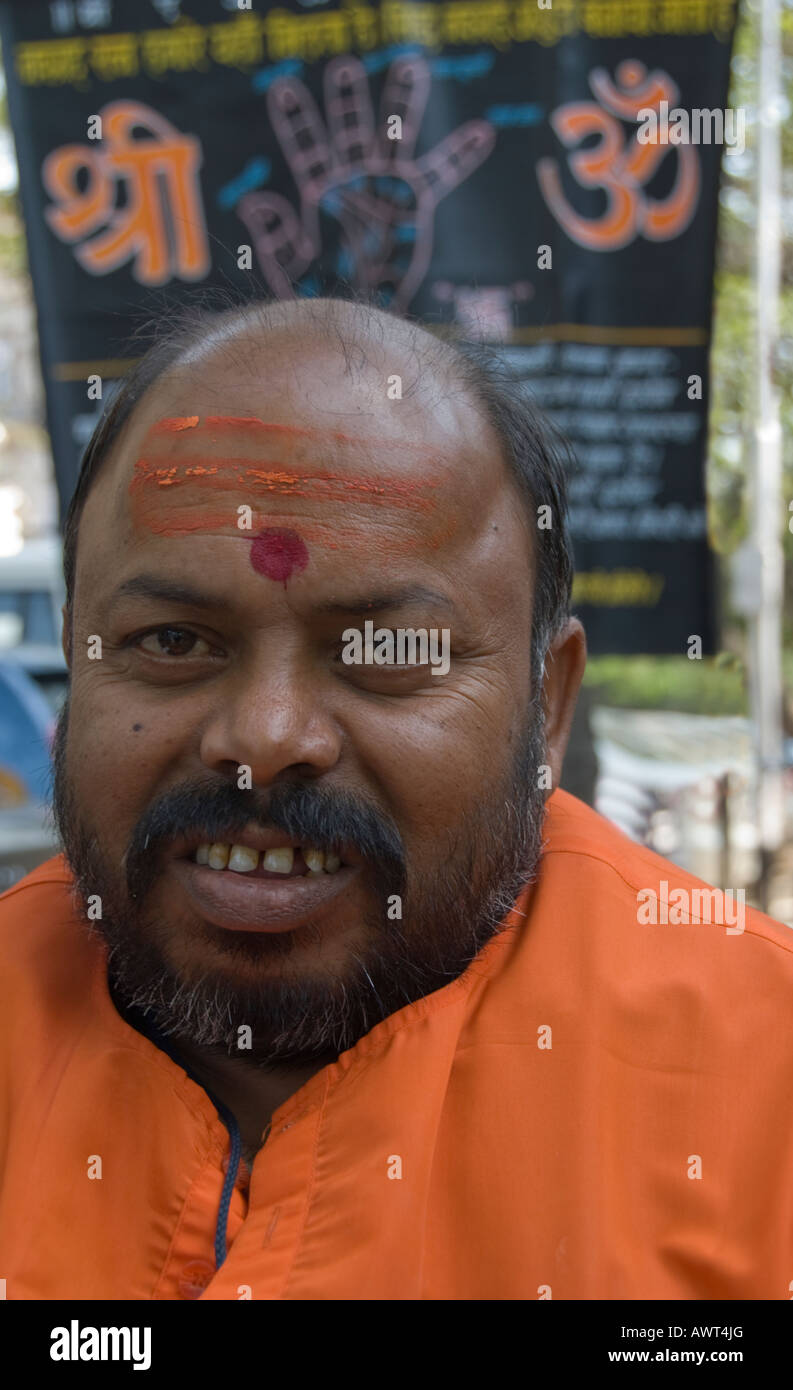 Porträt eines Palm Reader mit ein Werbeschild hinter ihm auf den Straßen von Mumbai, Indien. Stockfoto