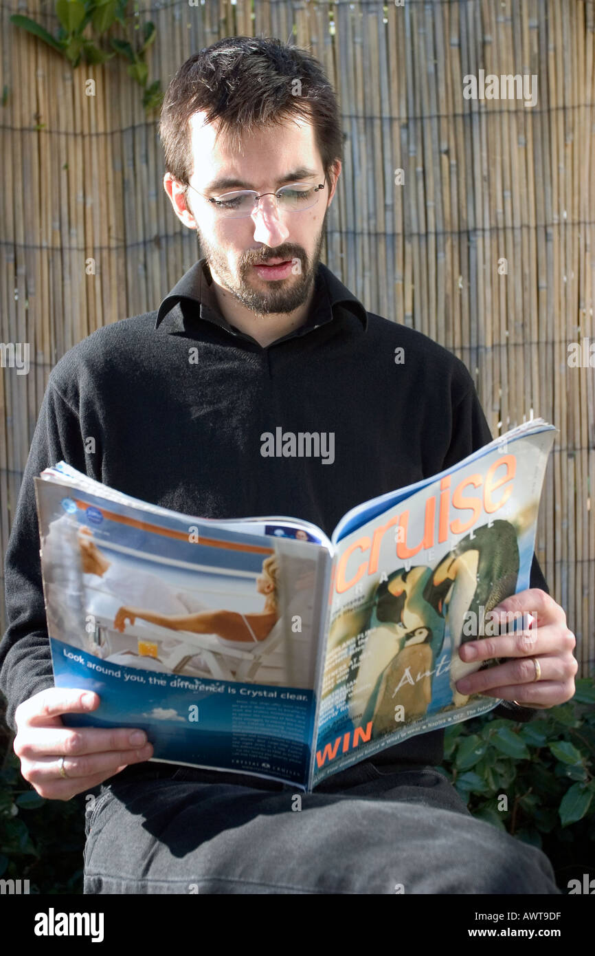 Mann liest Kreuzfahrten Magazin im hotel Stockfoto
