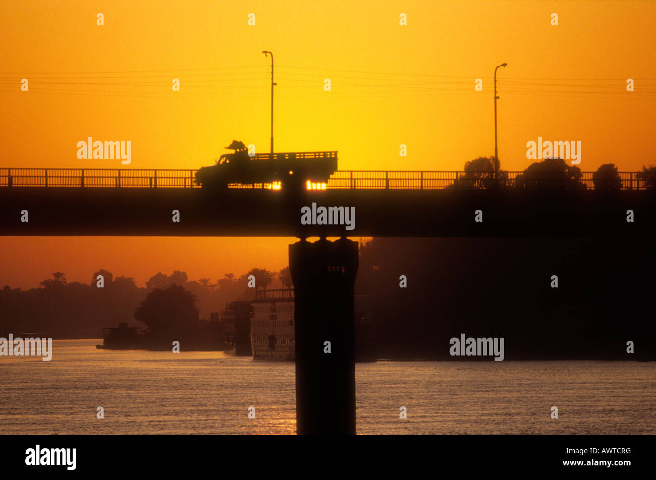 Ein LKW über eine Brücke über den Nil bei Sonnenaufgang. Stockfoto