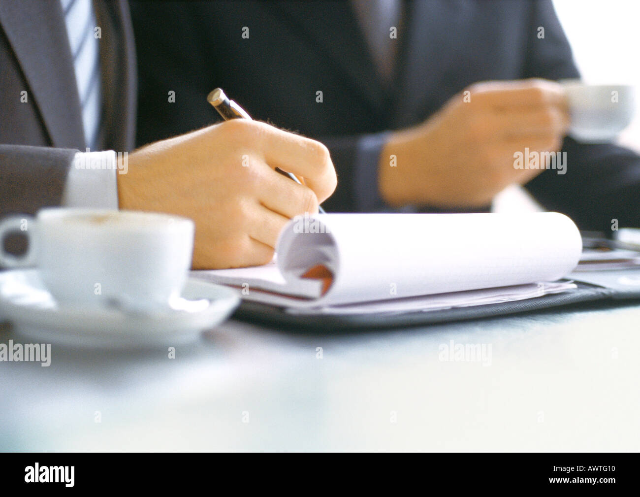 Unternehmer, die in der Nähe von Geschäftsmann Holding Cup schreiben Stockfoto