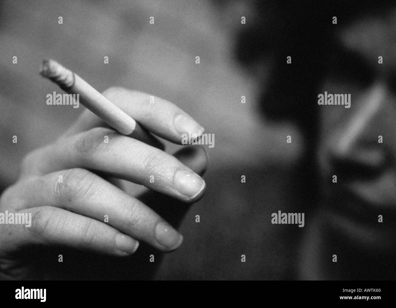 Frau Hand Holding Zigarette, close-up, verschwommen, b&w Stockfoto