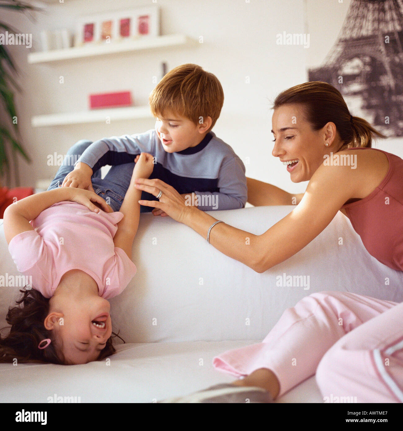 Kinder spielen mit Mutter auf couch Stockfoto