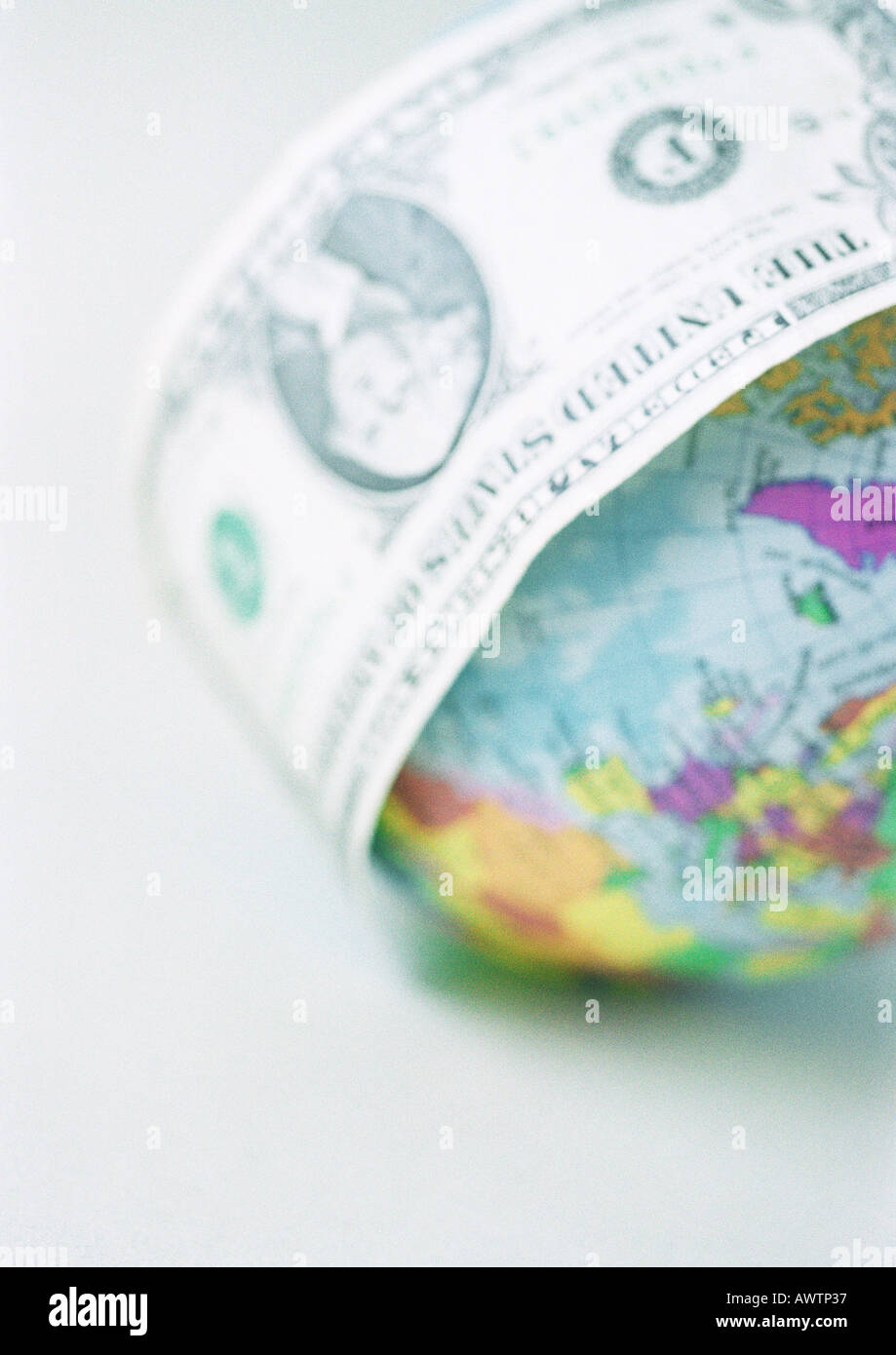 Eine Dollarnote umwickelt Globus, Nahaufnahme Stockfoto