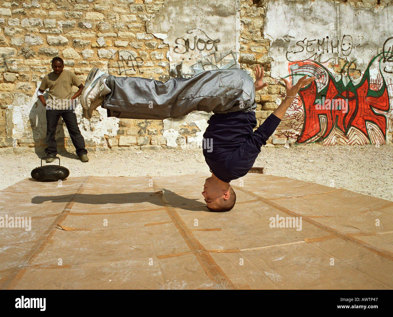 Mann, balancieren auf Kopf, Breakdance, Mann im Hintergrund beobachten Stockfoto