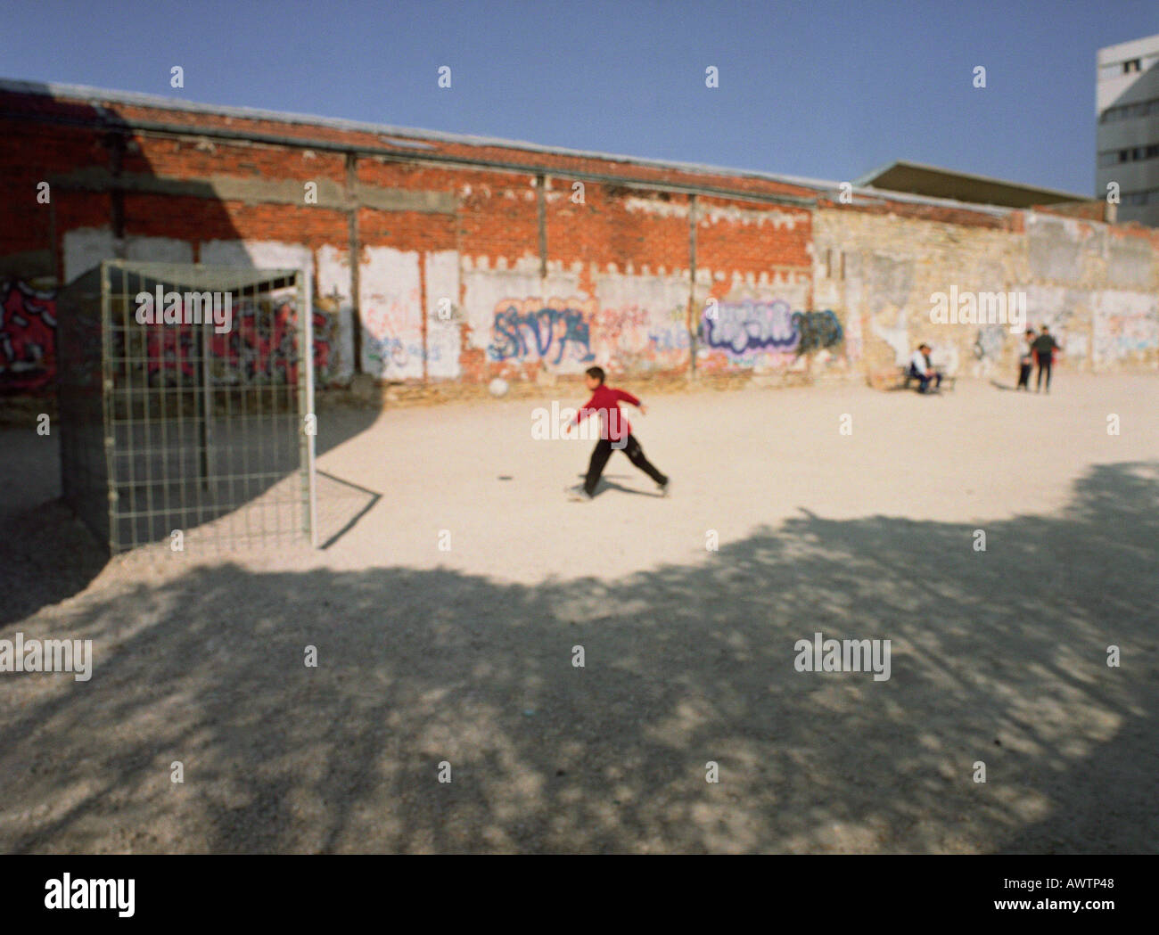 Fußball auf Schmutz Hof neben Graffitiwand spielt Stockfoto
