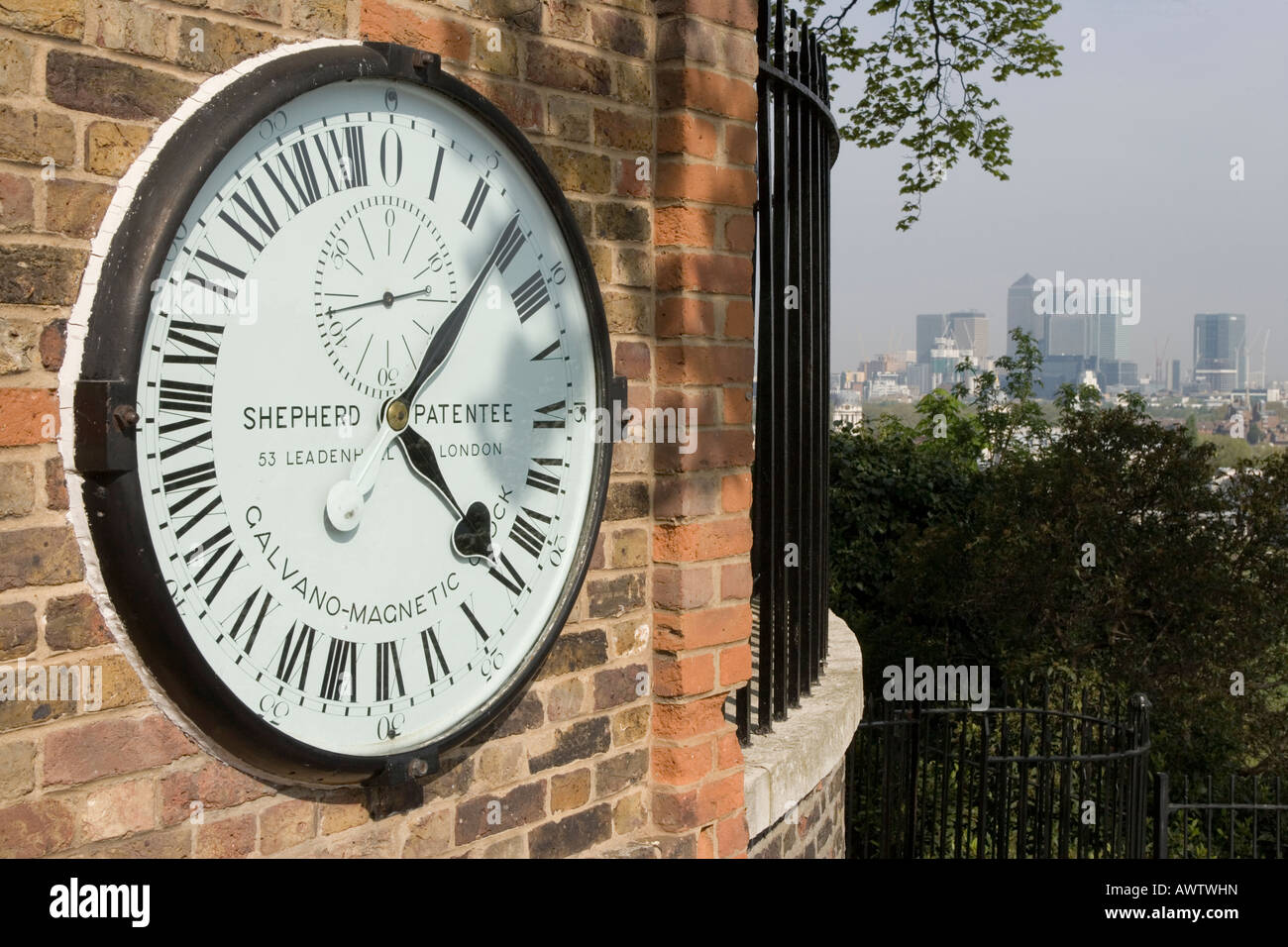 24-Stunden-Uhr am Observatorium in Greenwich, London.  Canary Wharf Hochhäuser im Hintergrund. Stockfoto