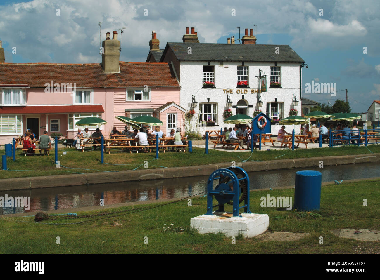 Die Old Ship Inn and Cottages am Ufer des Flusses Blackwater Leute an der Wasserseite Tische im Freien Heybridge Basin in der Nähe von Maldon Essex England Großbritannien Stockfoto