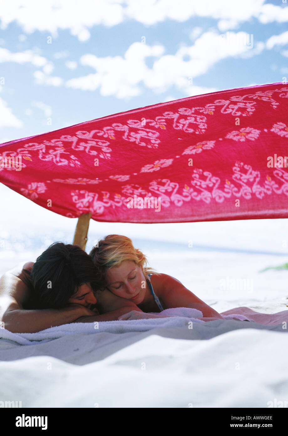 Paar Nickerchen im Schatten am Strand Stockfoto