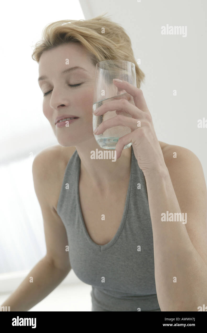 Eine Frau mit einem Glas Wasser, schloss die Augen Stockfoto