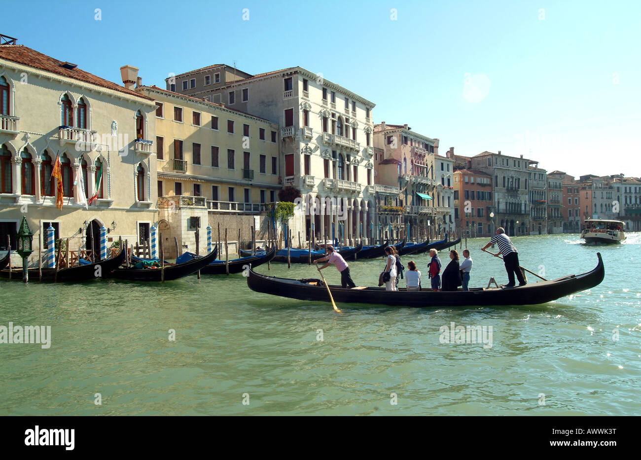 Gondel-Taxi überqueren den Canal Grande, Venedig, Italien an einem blauen fuhr Sommertag. Stockfoto