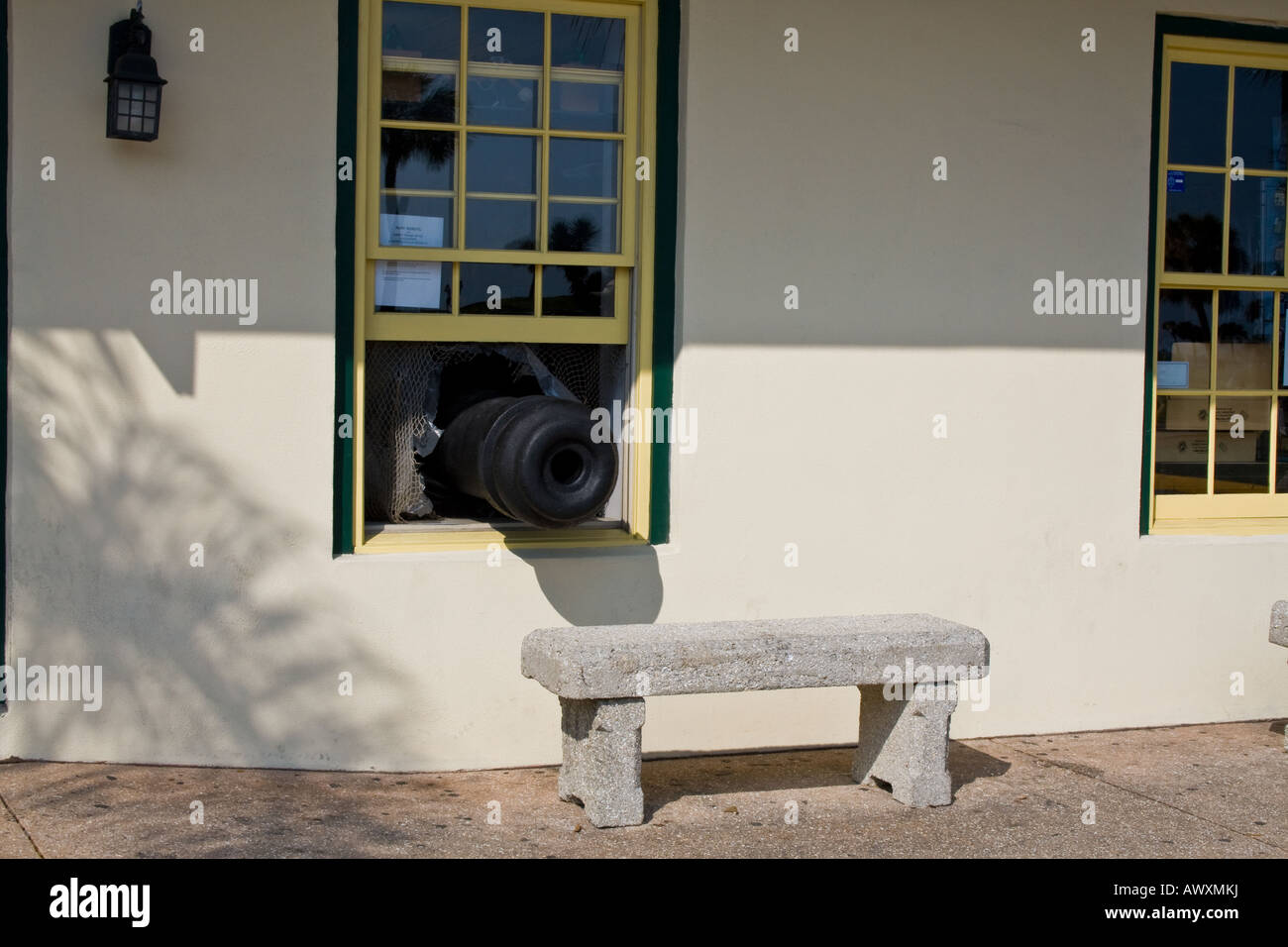Alte schwarze Kanone zeigt ein Fenster an einem sonnigen Tag über eine Zement-Bank in St. Augustine Florida Stockfoto