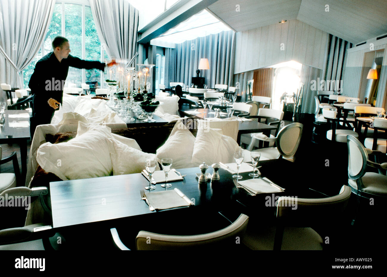 Paris Frankreich, Französisch trendy Restaurant, entworfen von Designer Philippe STARCK 'Bon' Interior Dining Room Mann bereitet Tische, europäisches Restaurant Stockfoto