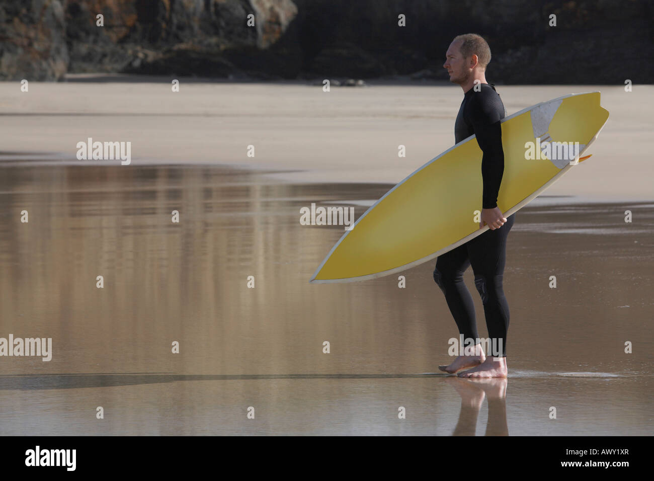 Mann mit Surfbrett am Strand, Seitenansicht Stockfoto