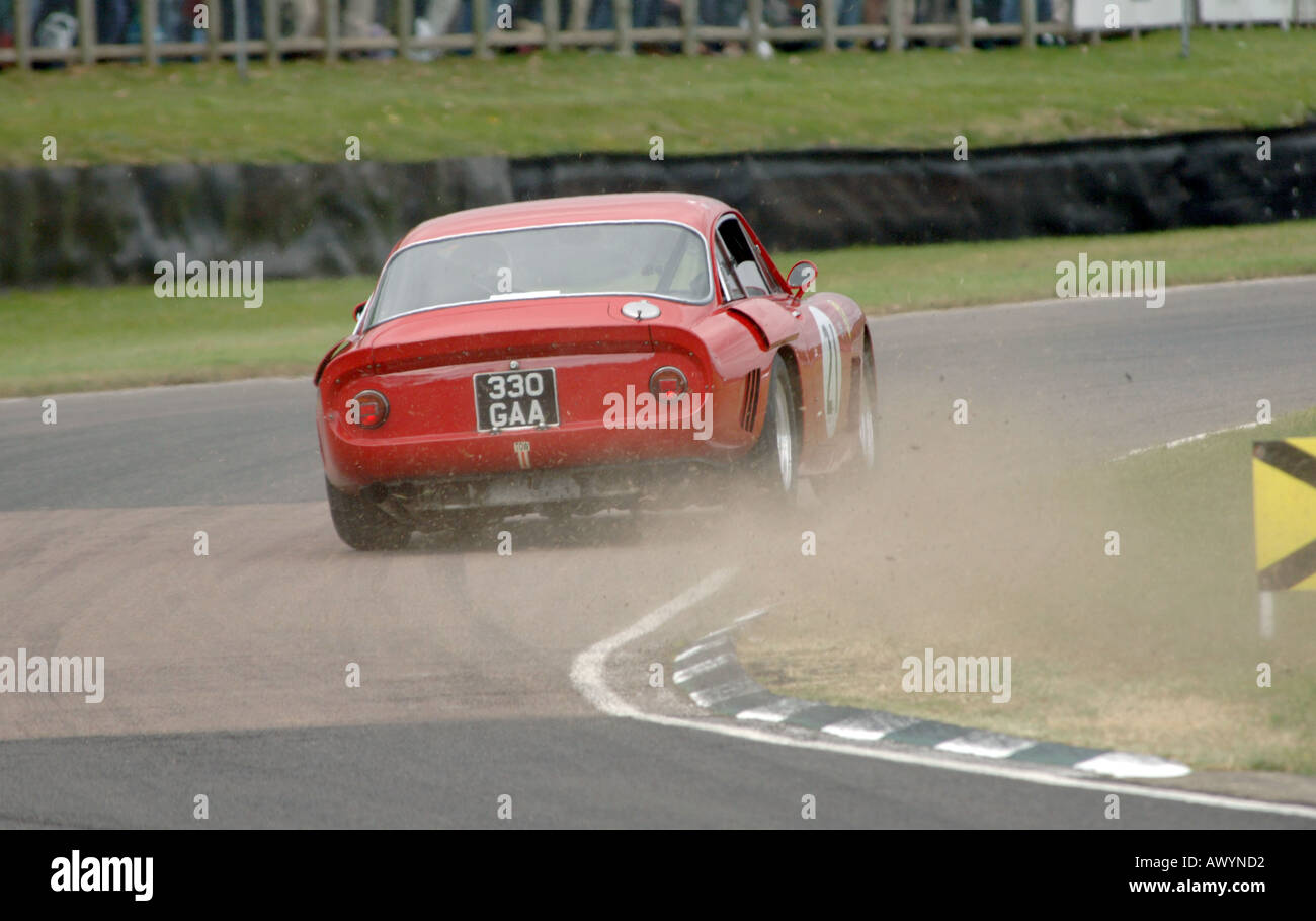 Ferrari-Rennwagen tritt Schmutz in einer engen Kurve beim Goodwood Revival Stockfoto