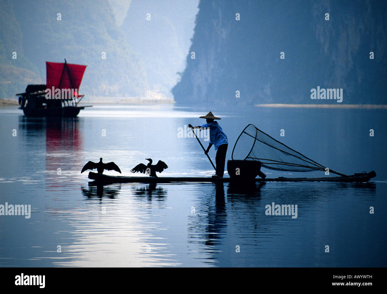 Chinesische Kormoran Fischer auf Bambus-Floß und Trödel mit roten Segel am Li-Fluss in der Nähe von Xingping in Guilin Gebiet von China Stockfoto