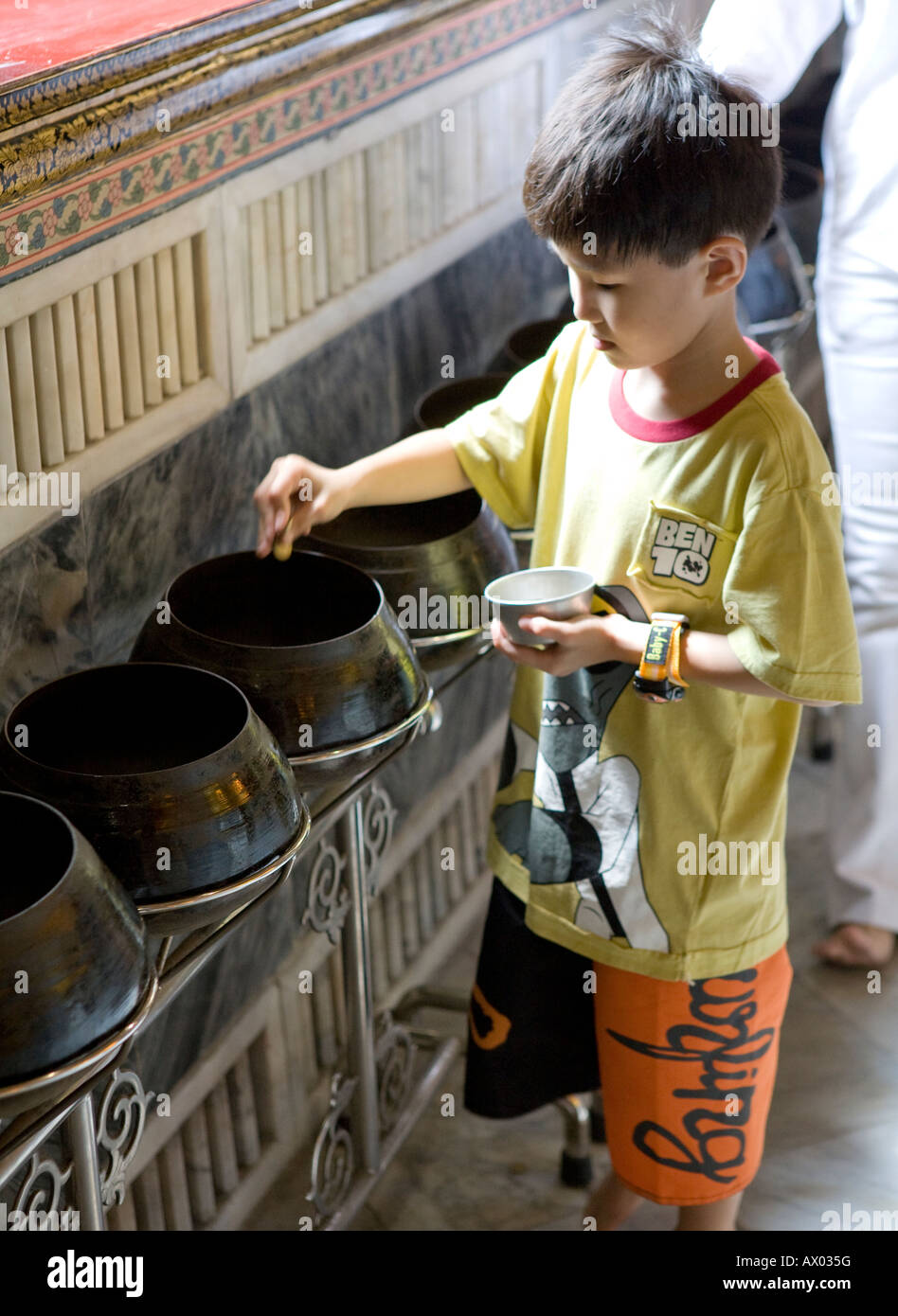 Junge Thai fallen Münzen in der Alms-Meditation-Sammlung Bowl Wat Po Thailand Süd-Ost-Asien Stockfoto