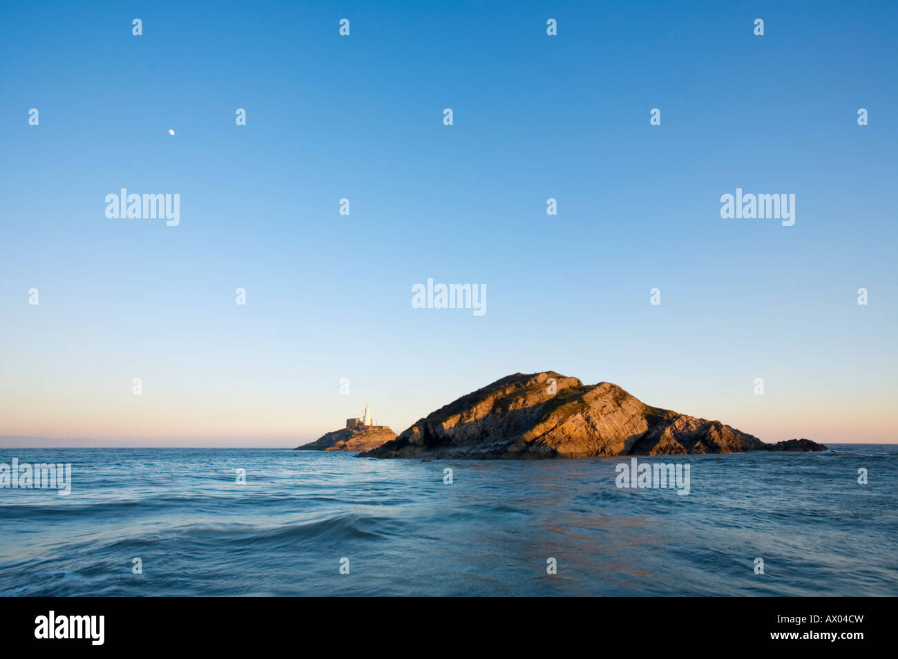 Mond steigt über Mumbles Head bei Sunset Gower Swansea Wales Stockfoto