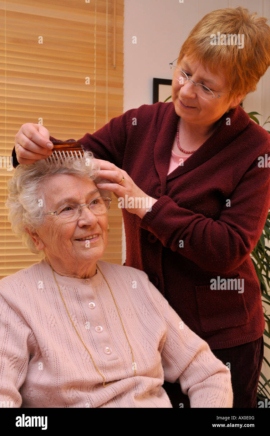 Hausmeister des älteren Patienten Haar kämmen Stockfoto