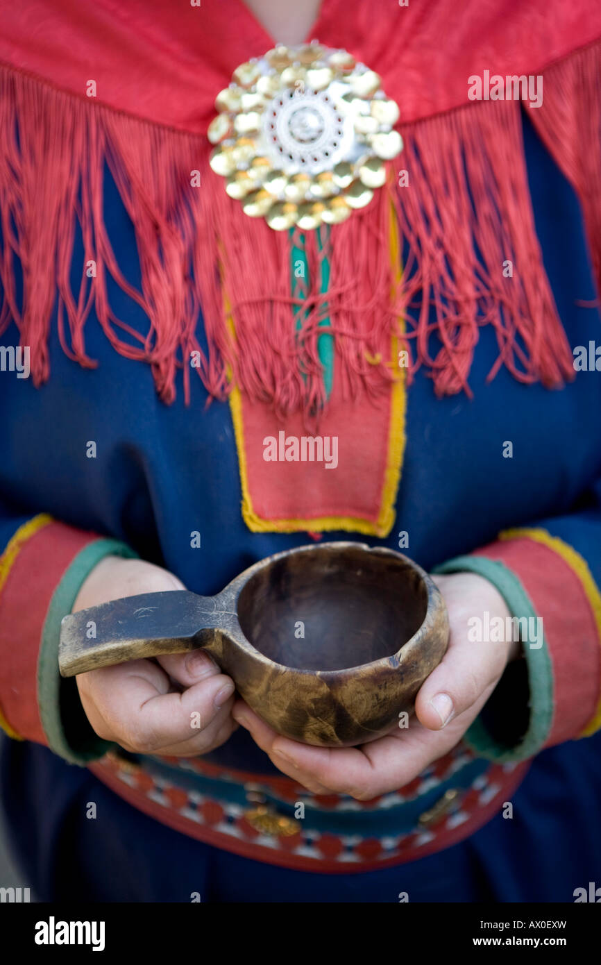 Sami-Frau in traditioneller Kleidung & trinken Cup, Inari, Lemmenjoki-Nationalpark, Lappland, Finnland Stockfoto