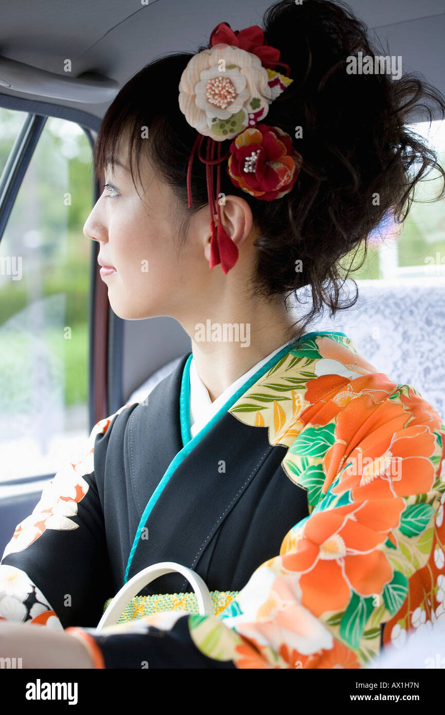 Eine Frau trägt einen Kimono in einem Auto Stockfoto