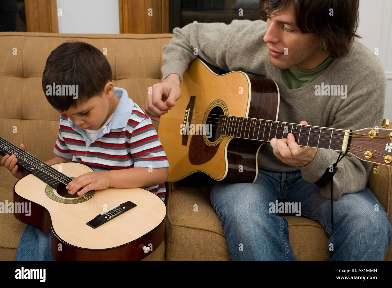 Ein Mann und eine junge, die Gitarre zu spielen Stockfoto