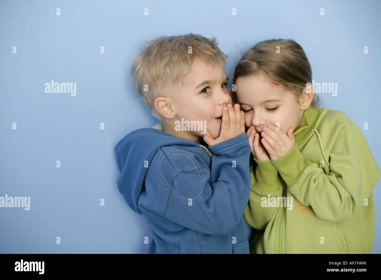 Kleine junge Mädchen ins Ohr flüstern Stockfoto