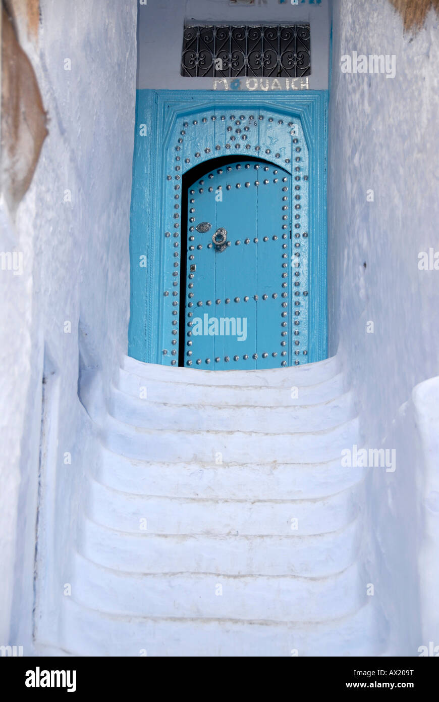 Weiße Treppe führt hinauf zu einem blauen Tor Medina Chefchaouen, Marokko Stockfoto