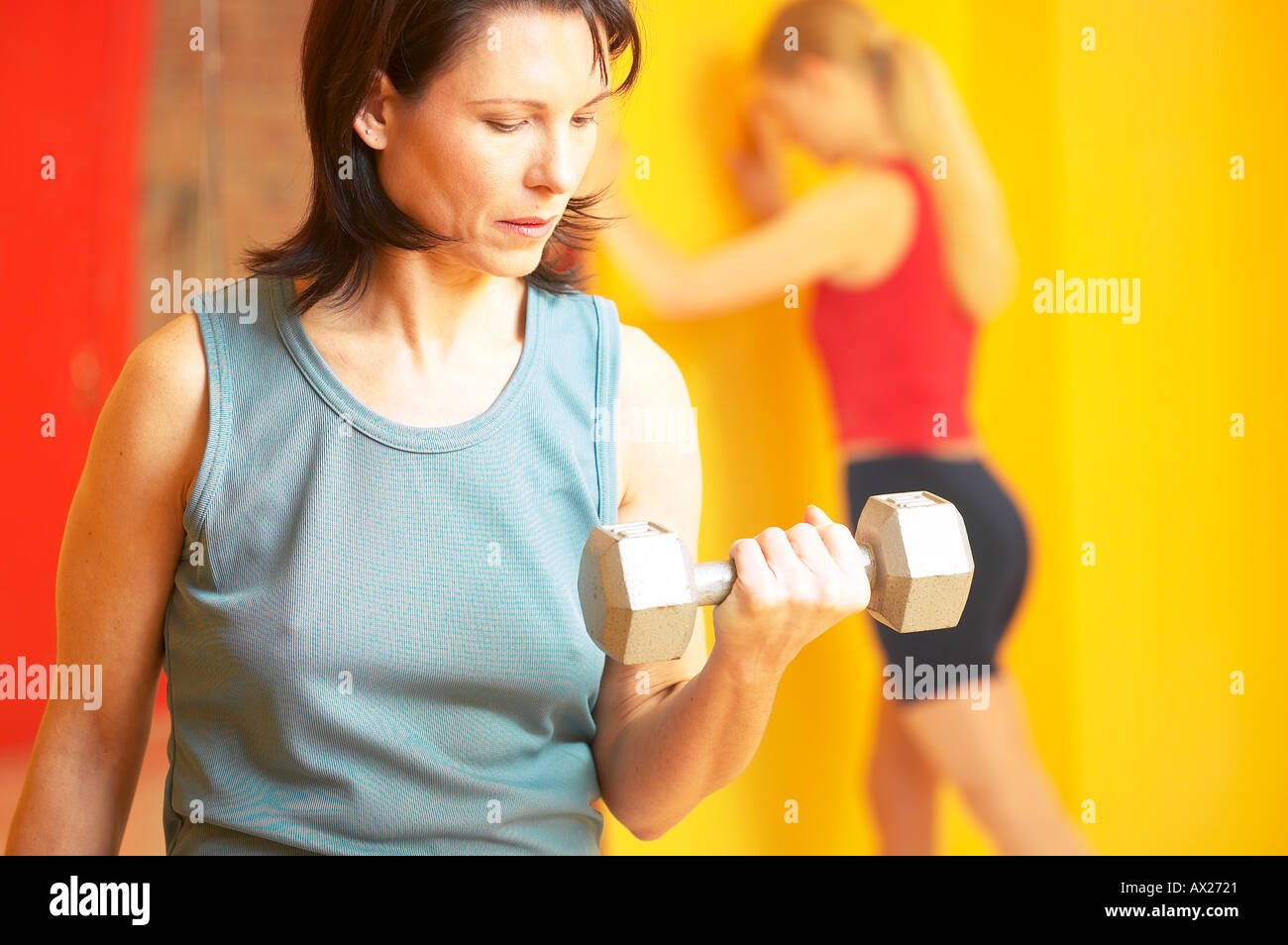 Reife Erwachsene Frau Heben von Gewichten mit Frau stretching im Hintergrund Uid 1427305 Stockfoto