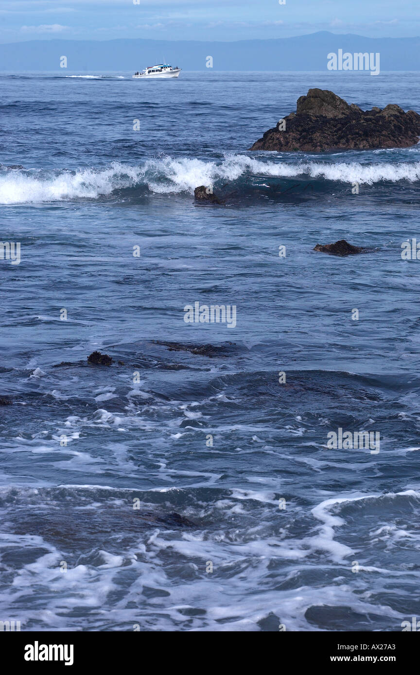 Wellen an der felsigen Küste mit Motorboot im Hintergrund Uid 1427561 Stockfoto