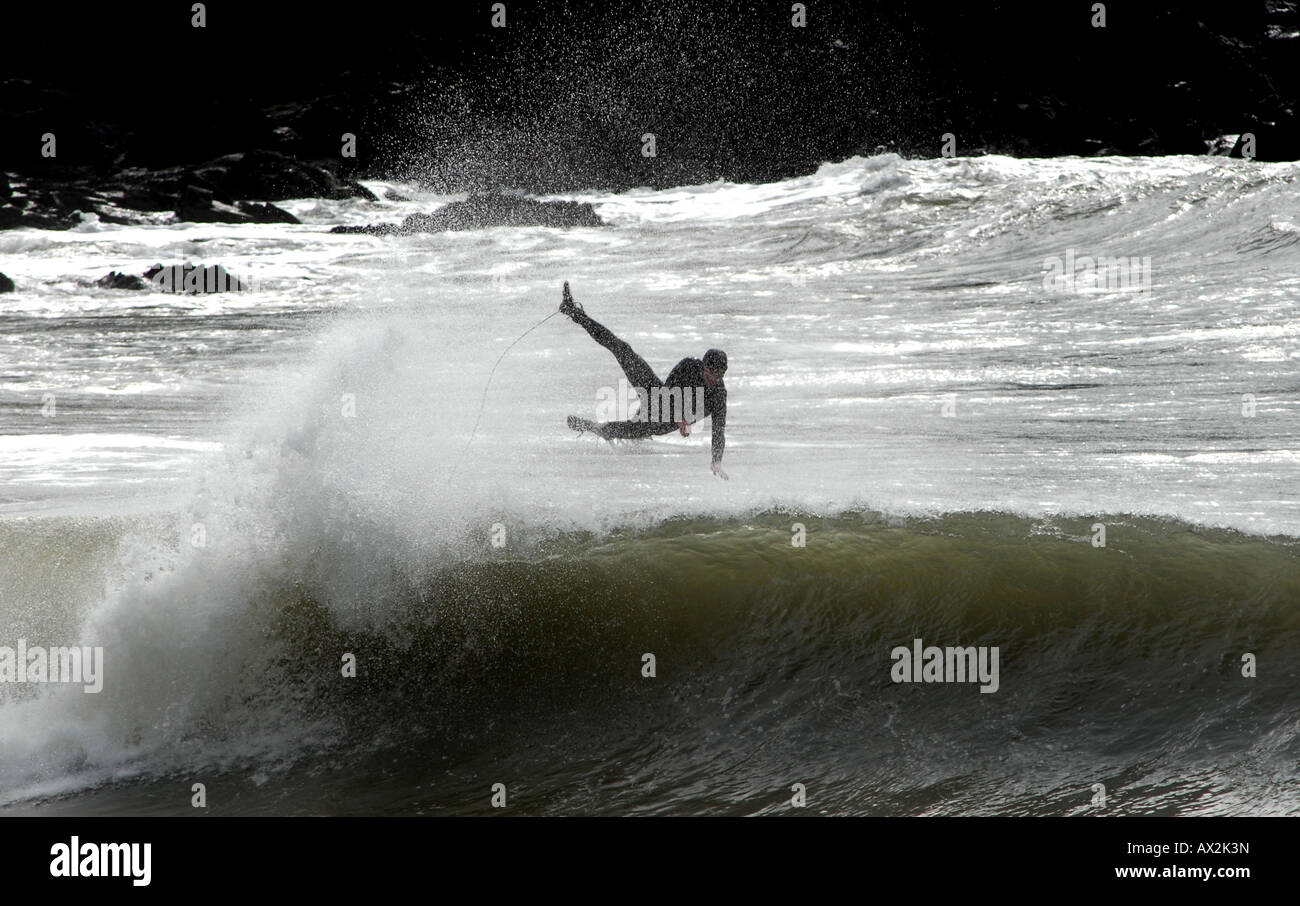 EINE WINTER-SURFER STÜRZT IN WELLEN AS HE TRYS, DIE BRANDUNG IN CHALLABOROUGH BAY,DEVON,ENGLAND.UK FAHREN Stockfoto