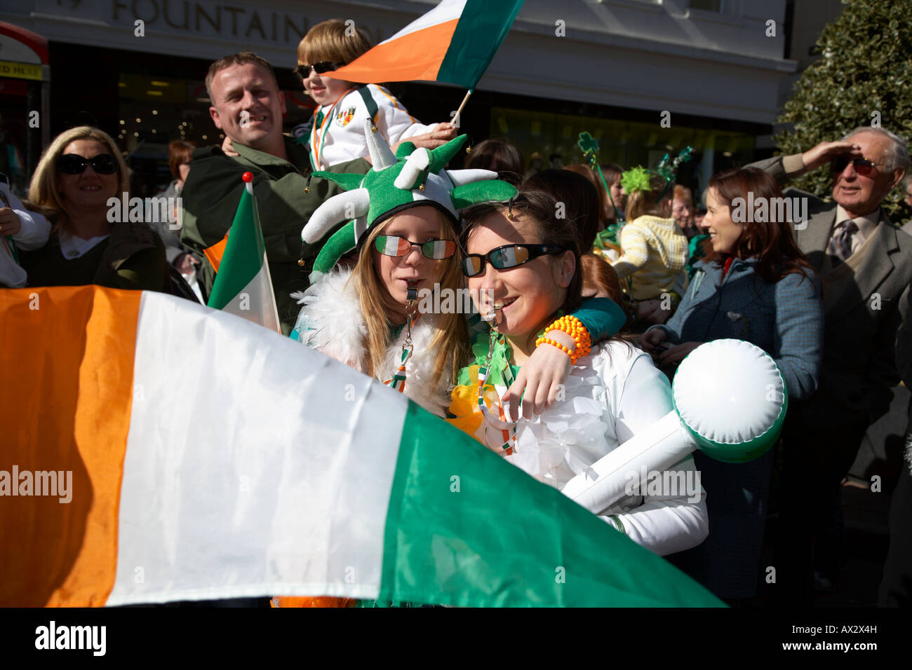 zwei junge Mädchen mit irische Flagge stehend warten auf die Parade und Karneval am St. Patricks Tag Belfast Nordirland Stockfoto