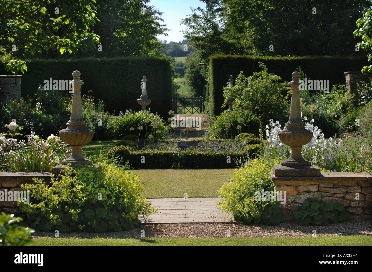 EIN PFAD, FLANKIERT VON ZWEI STEINSÄULEN IM GARTEN AM GUTSHOF SOMERSET
