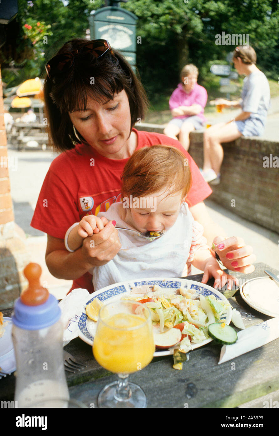 Baby versucht einige echte Lebensmittel von Müttern Platte Stockfoto