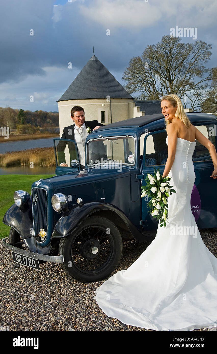 Großbritannien, Nordirland, Fermanagh, Enniskillen. Braut und Bräutigam geht weg in einem Oldtimer von ihrer Hochzeit. Stockfoto