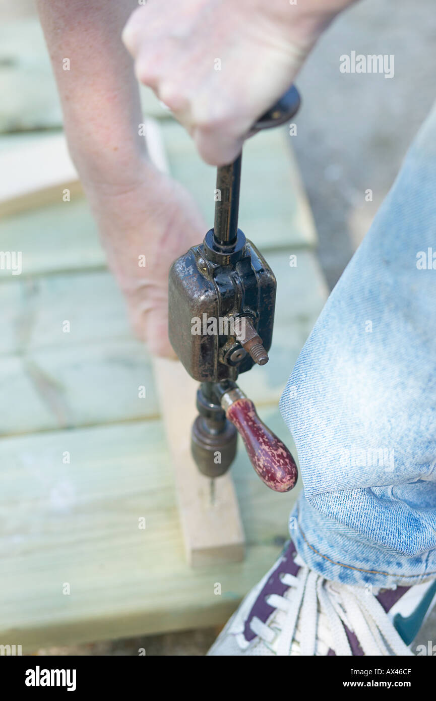 Weibliche Schreiner Arbeiten im Freien mit Handbohrer Stockfoto